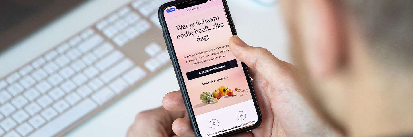 B2C-commerce-oplossingen-touchtribe Persoon bekijkt een webshop op zijn mobiele telefoon